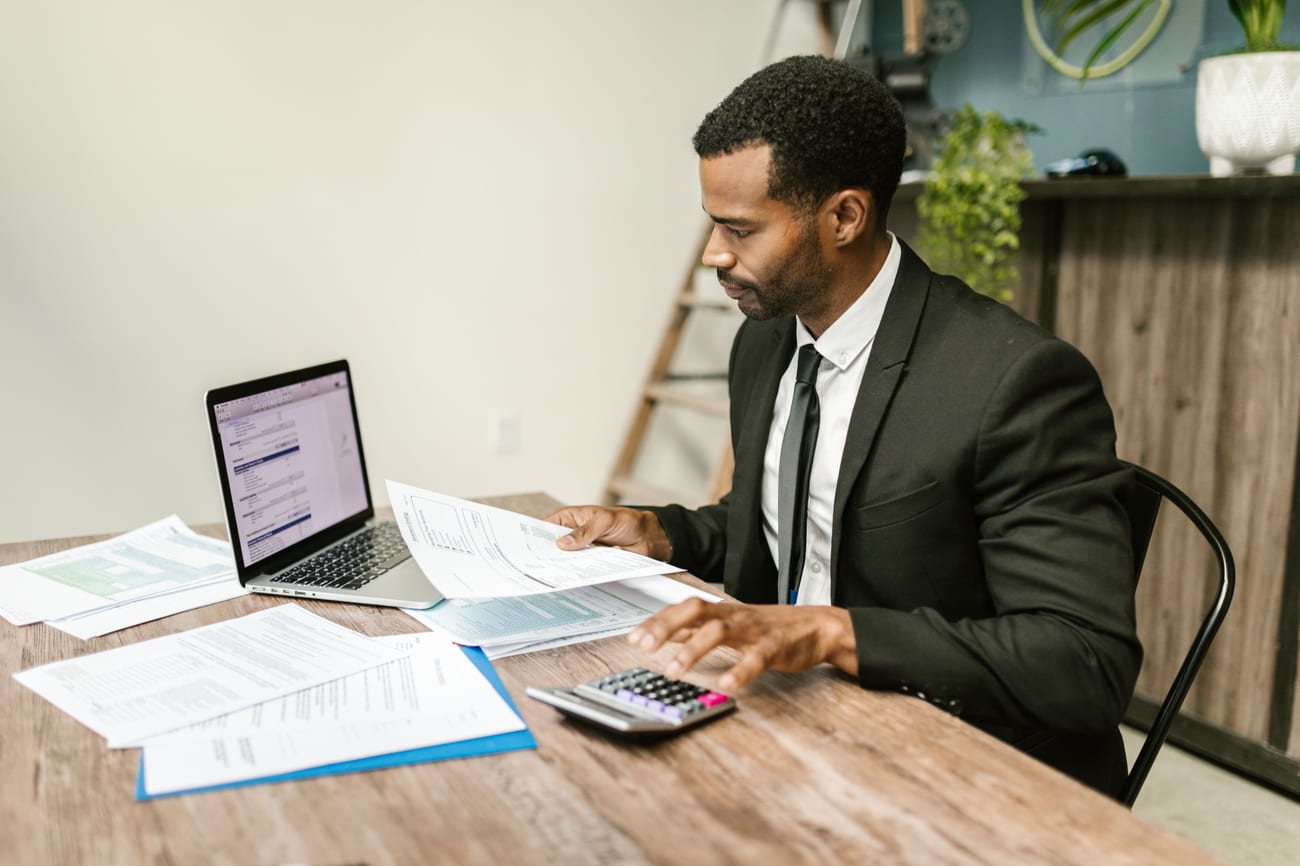 An FX broker reviewing paperwork at his desk