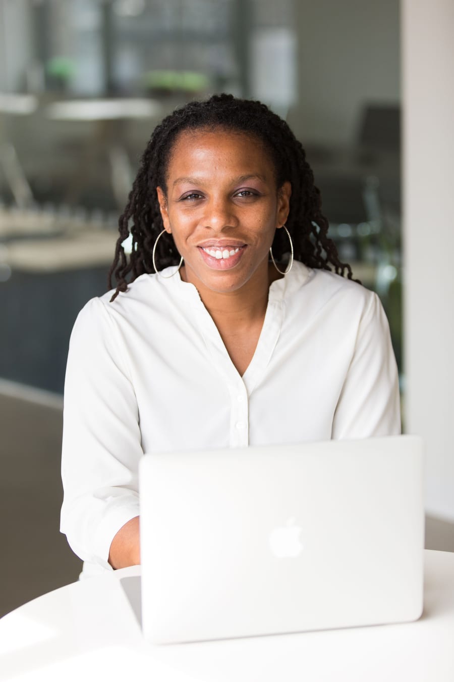 A merchant smiling at her laptop