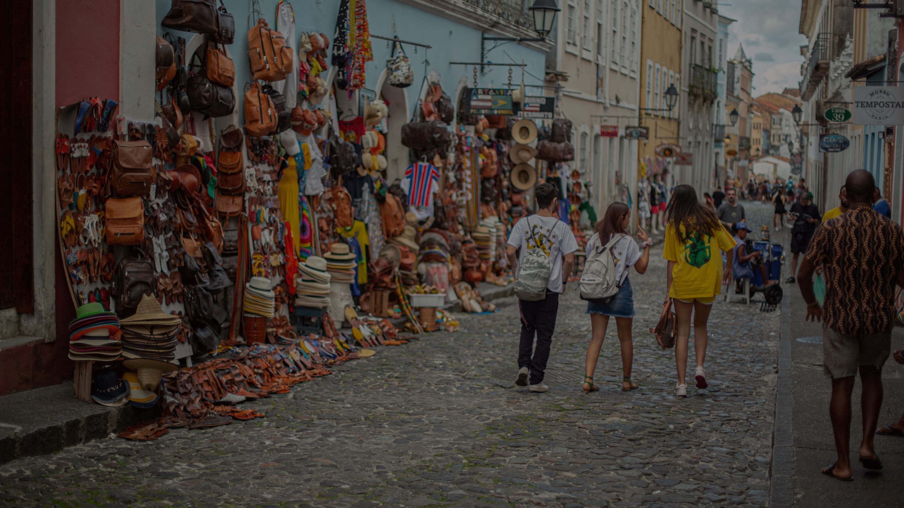 Shoppers walking down a colorful market street