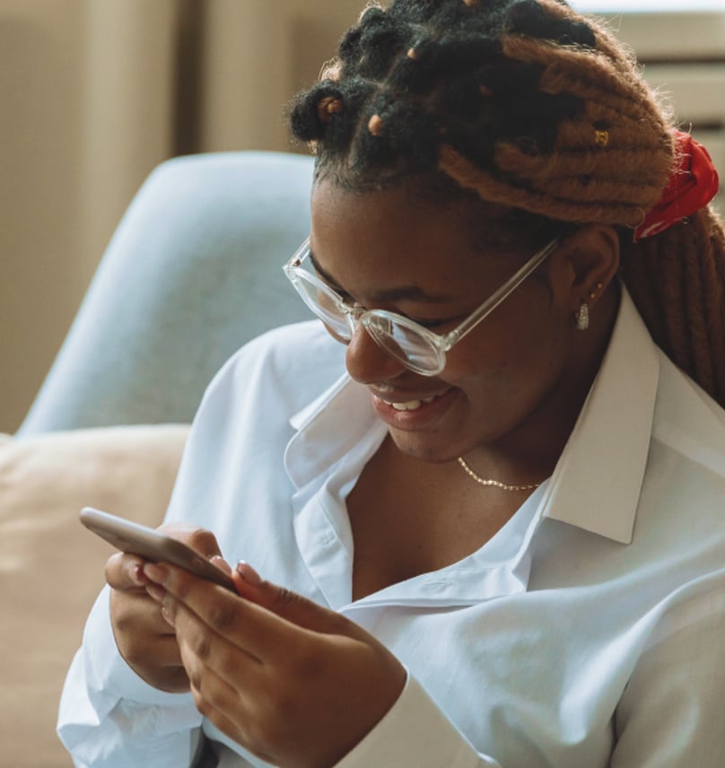 Woman smiling while using her phone